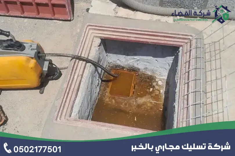 تسليك غرف التفتيش بالخبر: جهاز سلك كهربائي أصفر داخل غرفة تفتيش مربعة فيها ماء راكد